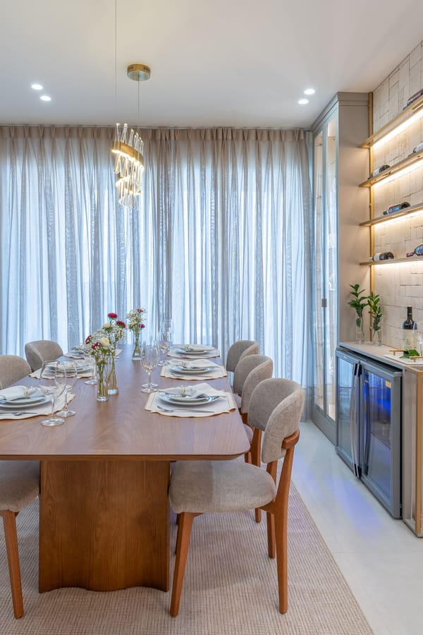 Mesa de jantar posta, com adega climatizada e nichos iluminados