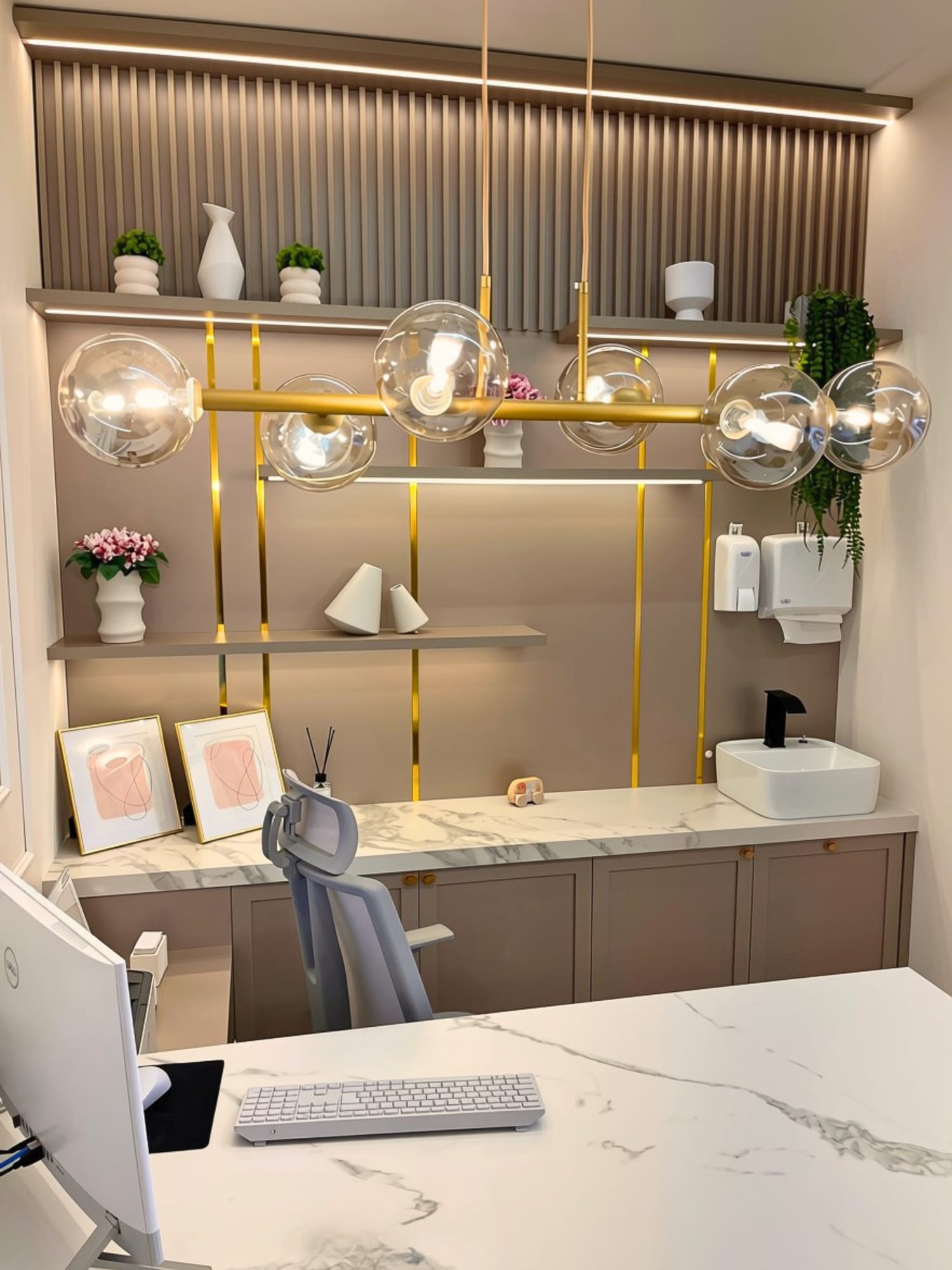 Bancada de atendimento com painel ripado, prateleiras iluminadas e pendentes de vidro