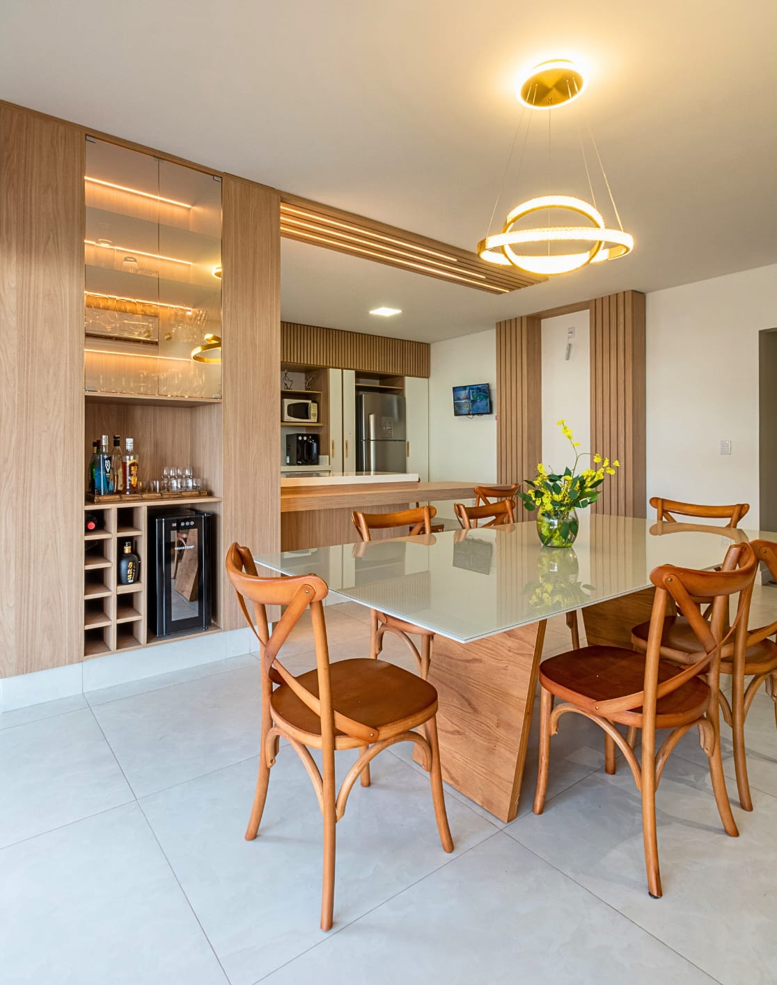 Sala de jantar com cadeiras em madeira, adega e pendente circular