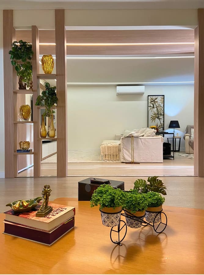 Living integrado com estante vazada em madeira e mesa de centro