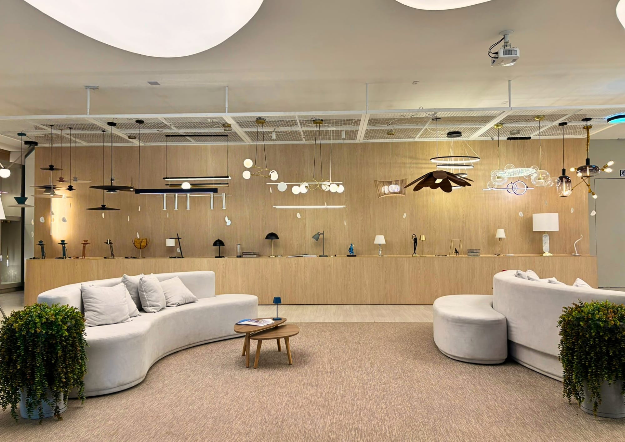 Showroom de iluminação com sofás curvos e luminárias em exposição